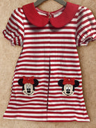 Red and white striped dress with faces on a beige surface