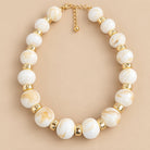 Ivory Marble Gold Bead Necklace is a women's ivory beaded statement necklace with gold-tone spacers.