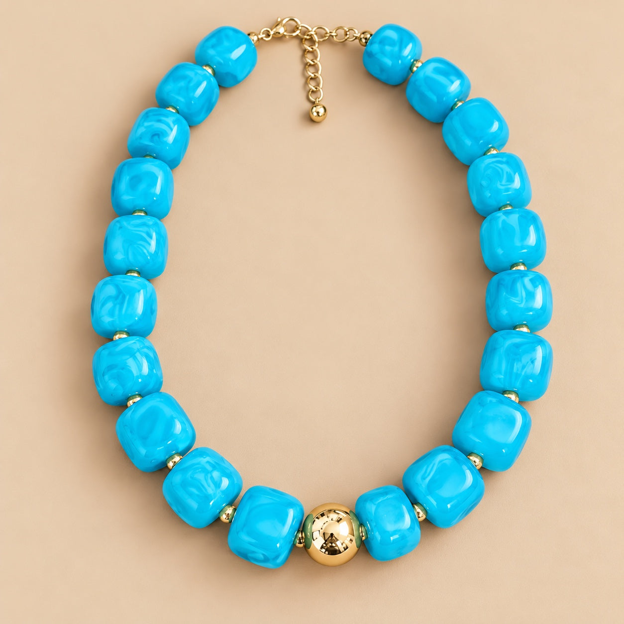 Aqua Blue Cube Bead Necklace is a women's aqua blue beaded statement necklace with gold-tone accents.