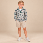 Boy wearing the Marsh Mud long-sleeve athletic camo quarter zip with a stand collar, styled with tan shorts.
