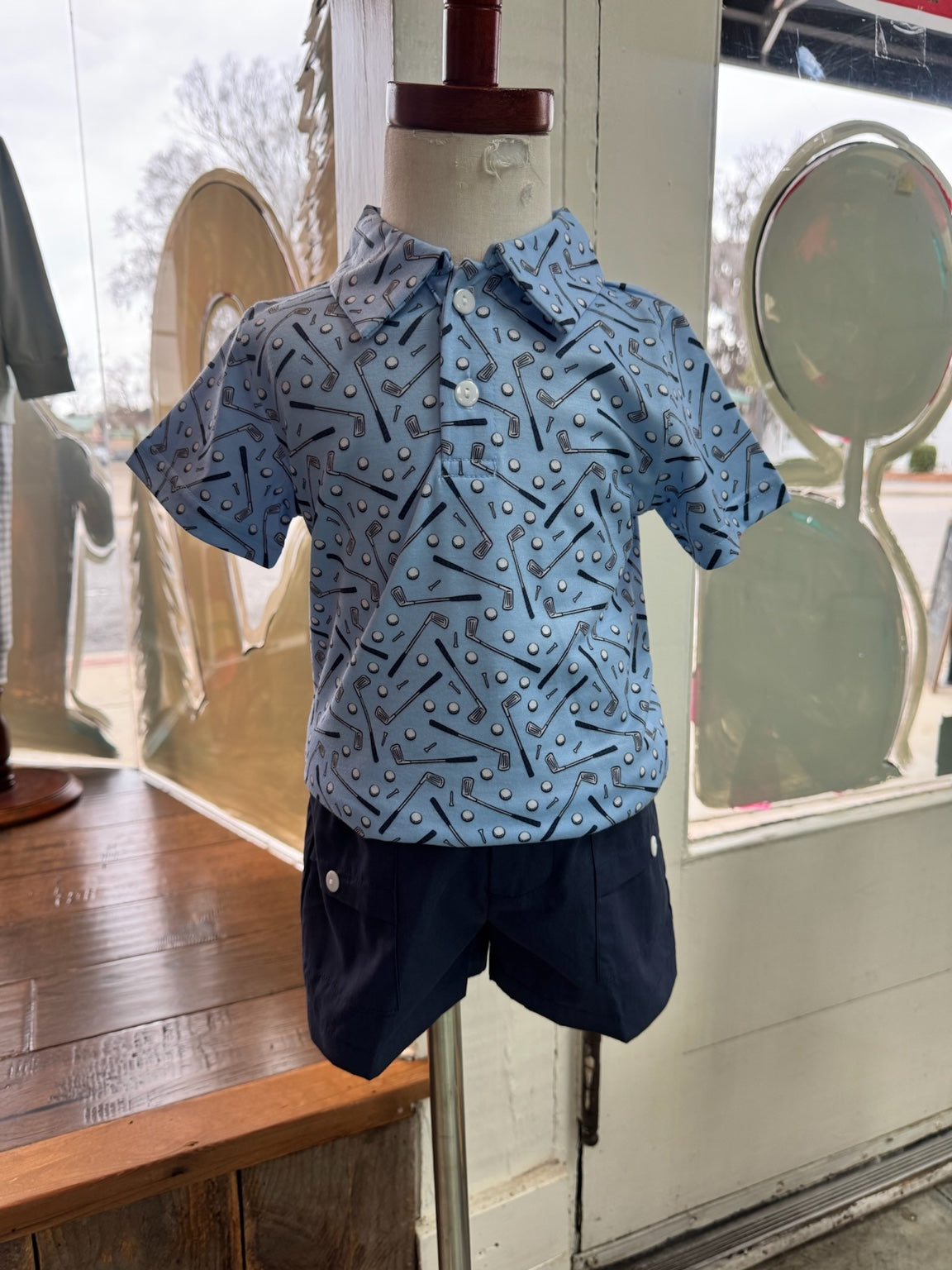 Boy golf outfit, light blue polo with navy blue shorts. 