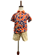 Colorful patterned shirt and beige shorts on a mannequin against a white background