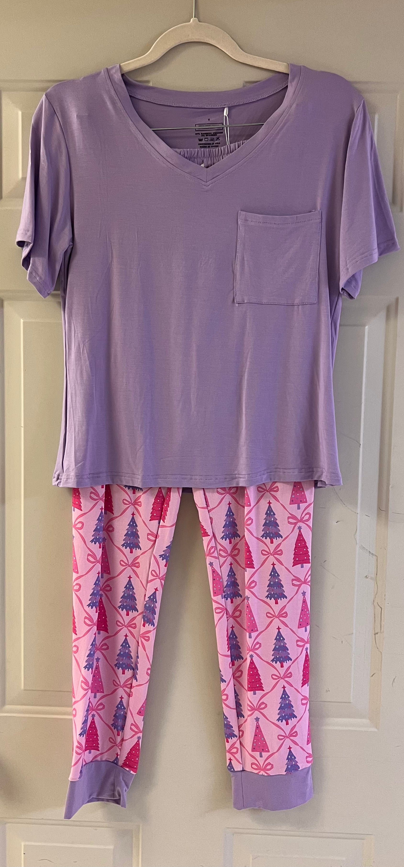Lavender short-sleeve top with pocket paired with pink lounge pants featuring purple and magenta Christmas trees and bows.