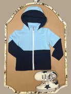 Blue and navy colorblock boys hoodie named “Zayne’s Zip-Up” displayed with white sneakers featuring navy stars from Southern Belle & Beaus.