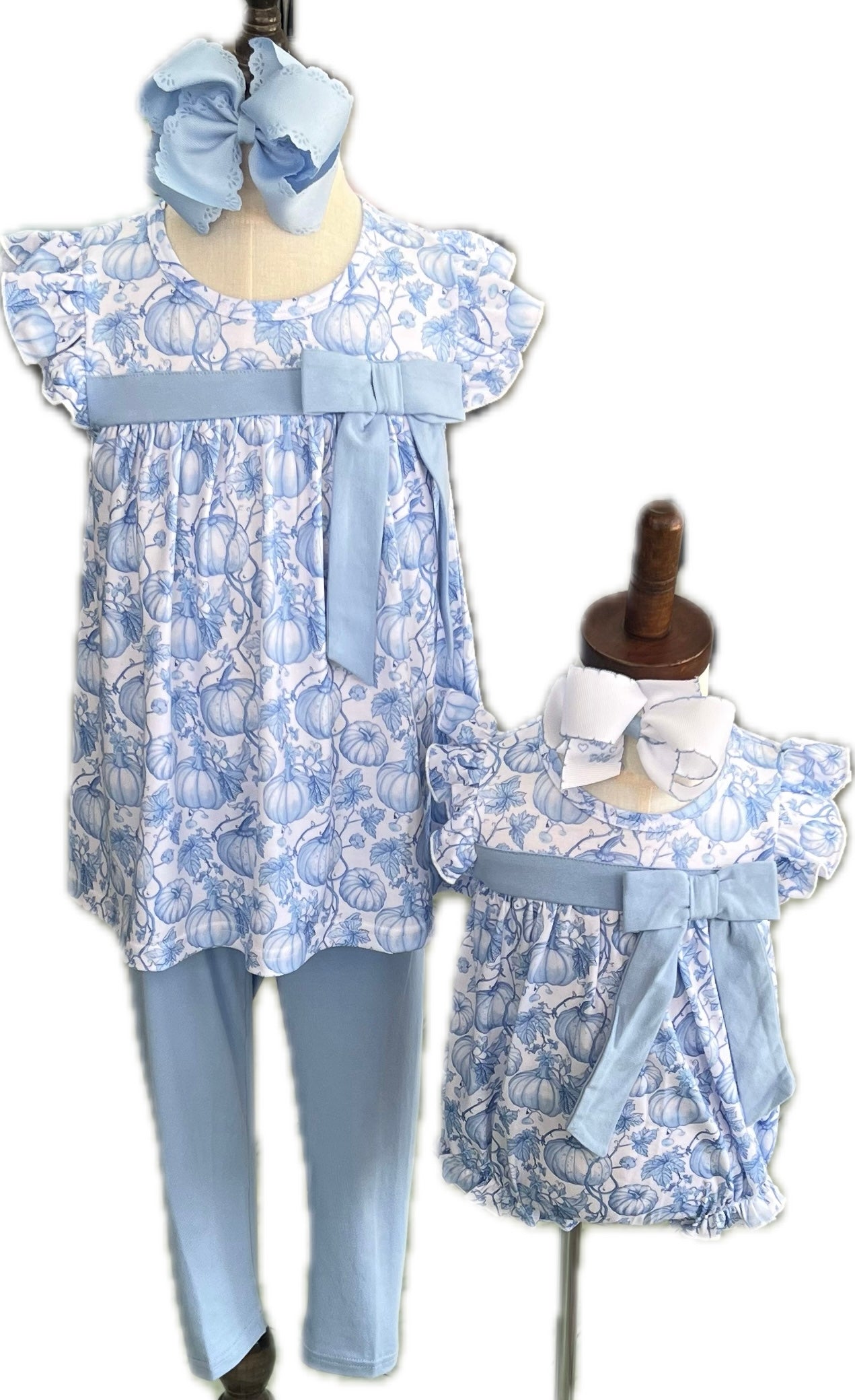 Children's outfit with floral dress and leggings on a mannequin, accompanied by a baby outfit on a smaller mannequin.