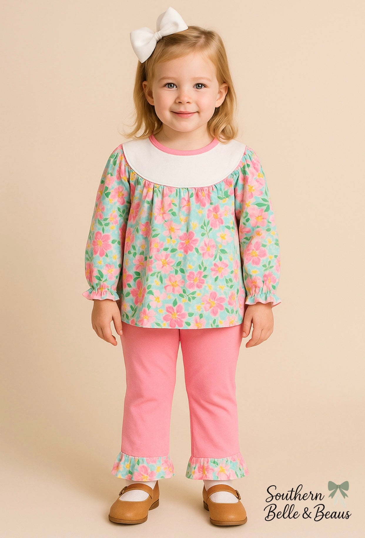 Little girl wearing the Garden Kisses Set with floral tunic and long pink ruffle pants