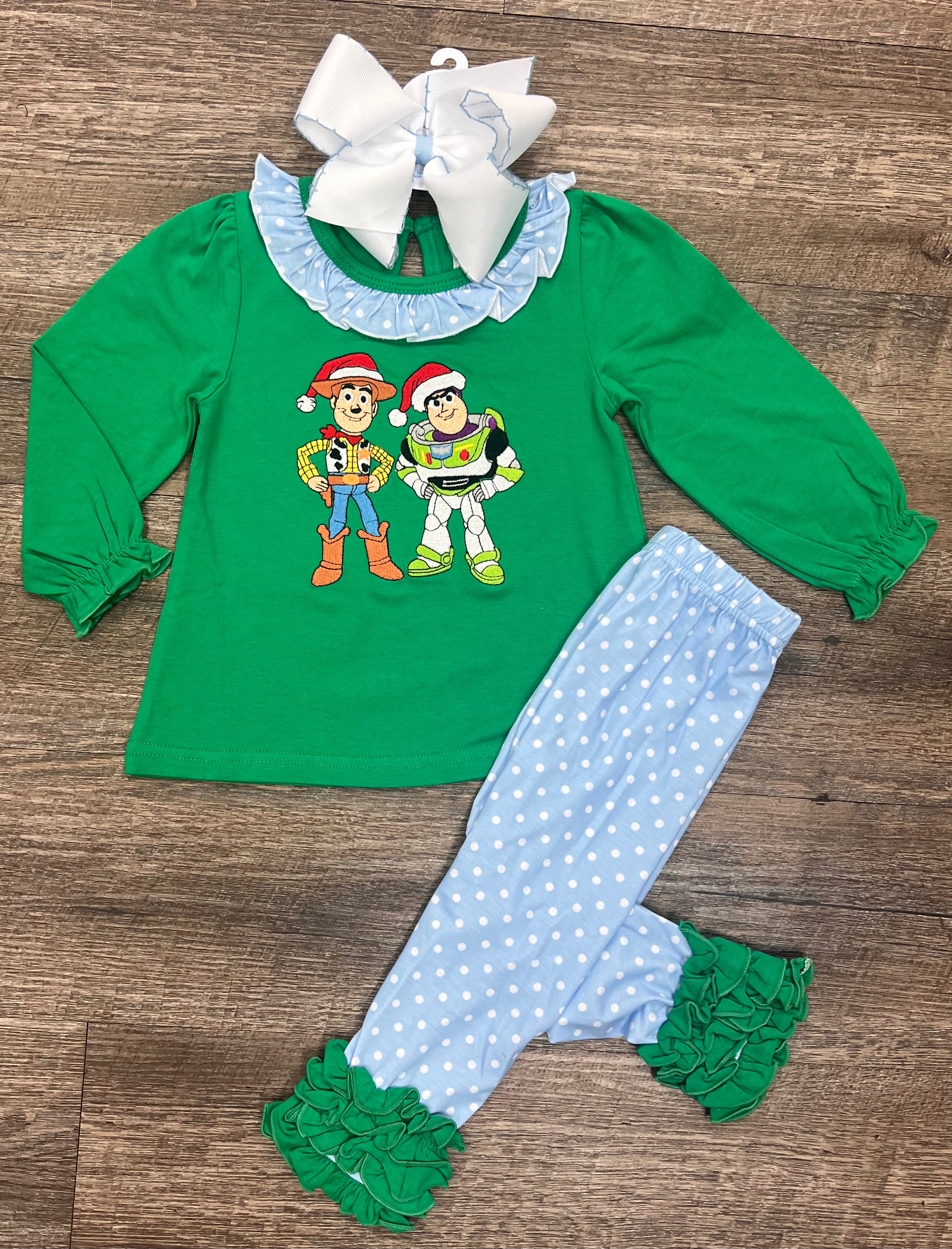 Girls Christmas ruffle outfit with cowboy and space ranger characters in Santa hats, green top with blue polka dot ruffles from the To the North Pole & Beyond Collection by Southern Belle & Beaus.