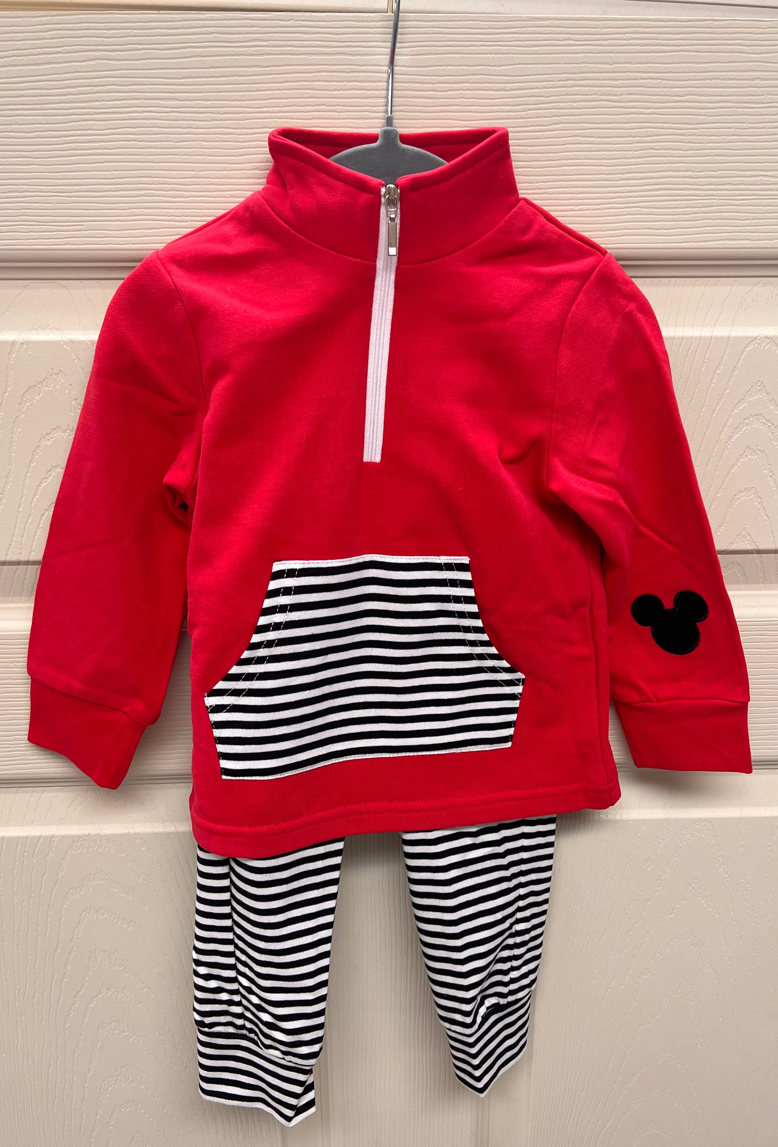 Red quarter-zip jogger set for boys featuring black-and-white striped joggers, matching striped pocket, and a small black mouse silhouette on the sleeve.