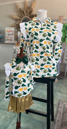 Children's outfit with football and cheer patterned top and gold skirt on a mannequin.