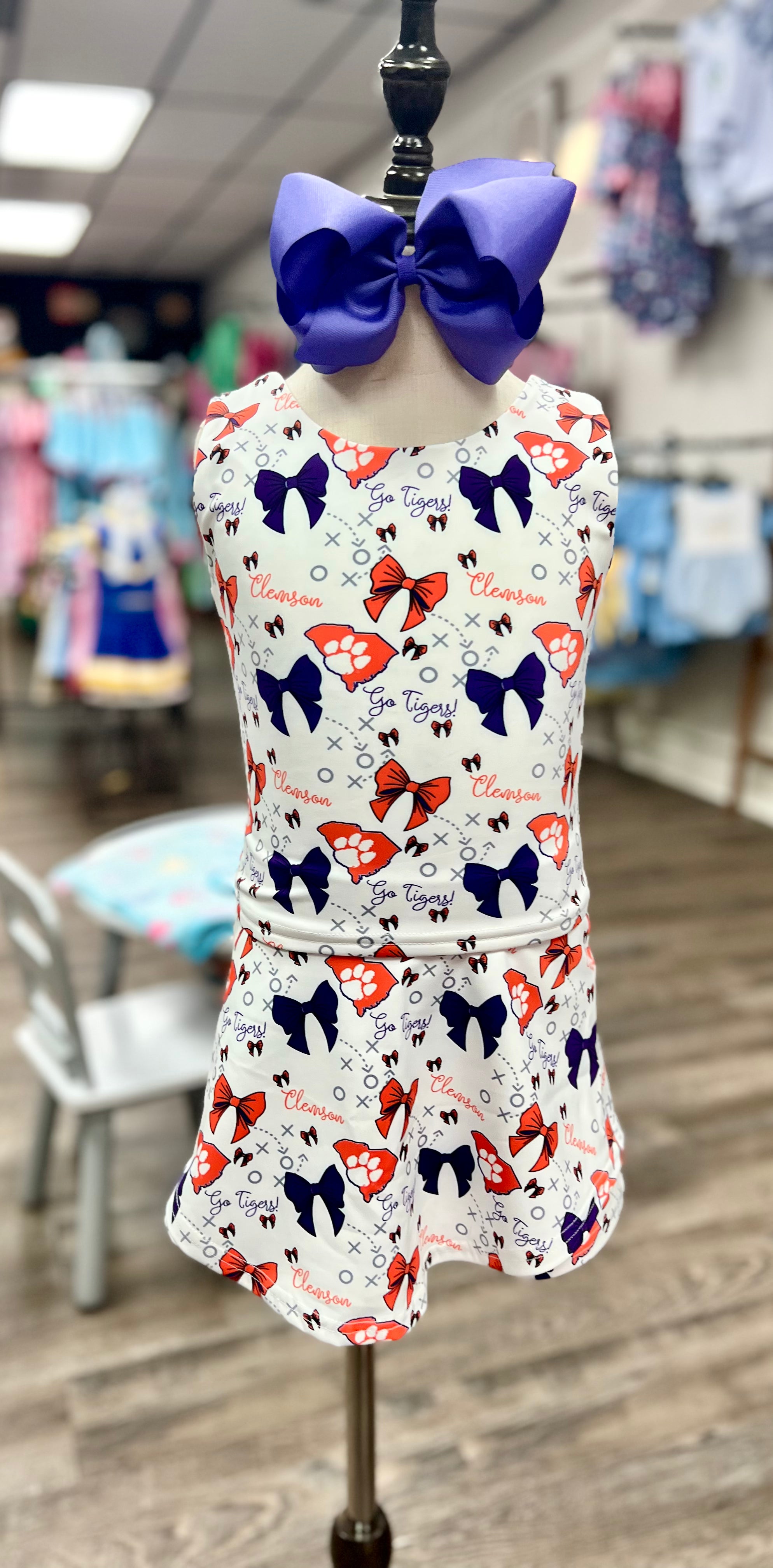 Children's dress with butterfly pattern on a mannequin in a store setting