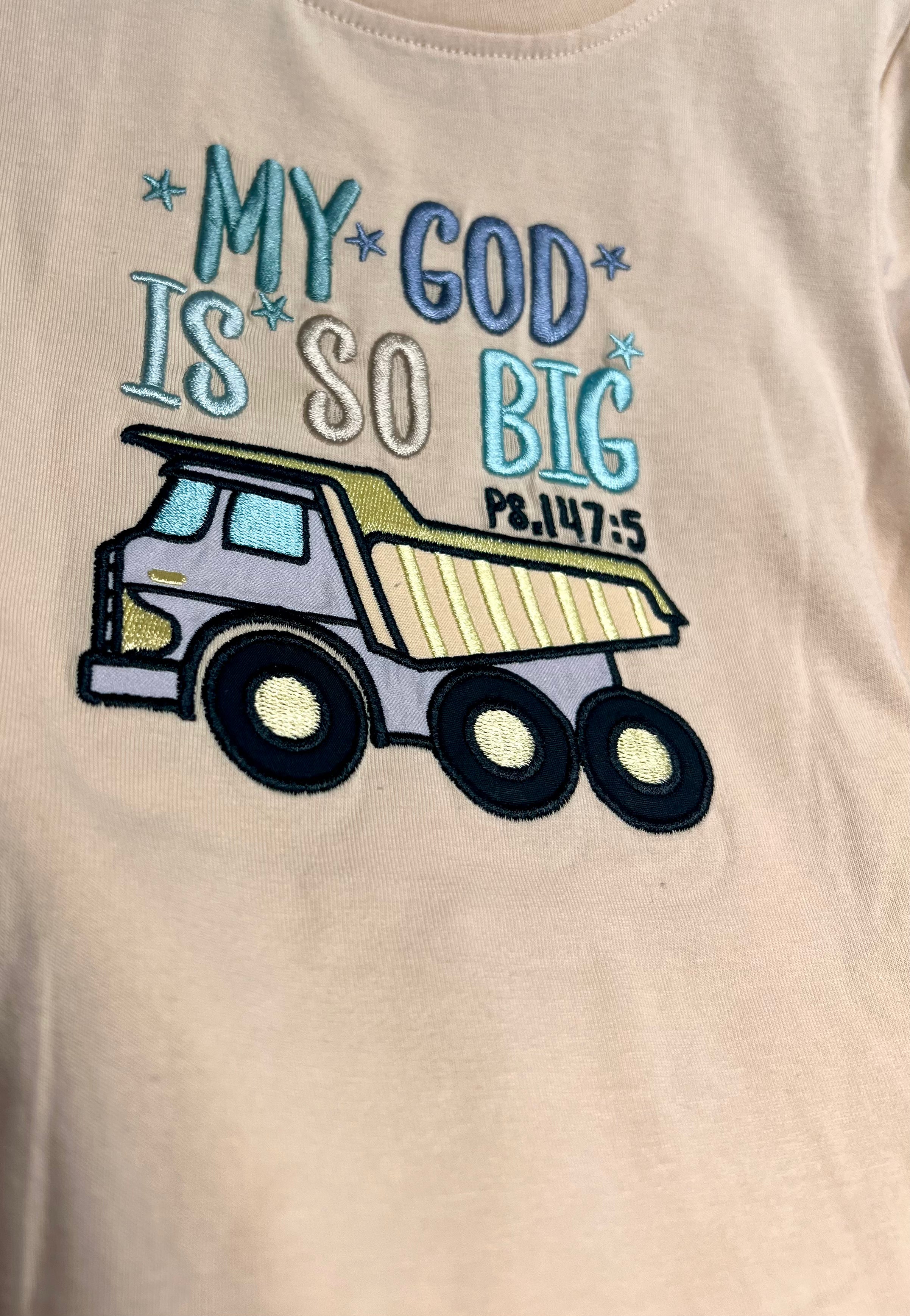 Beige t-shirt with a dump truck graphic and text 'My God is so big' on a beige background
