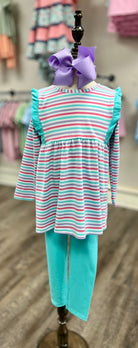 Striped dress and leggings set on a mannequin with a bow, against a store background.