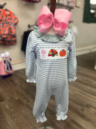 Children's outfit with striped design and pink bow on a hanger
