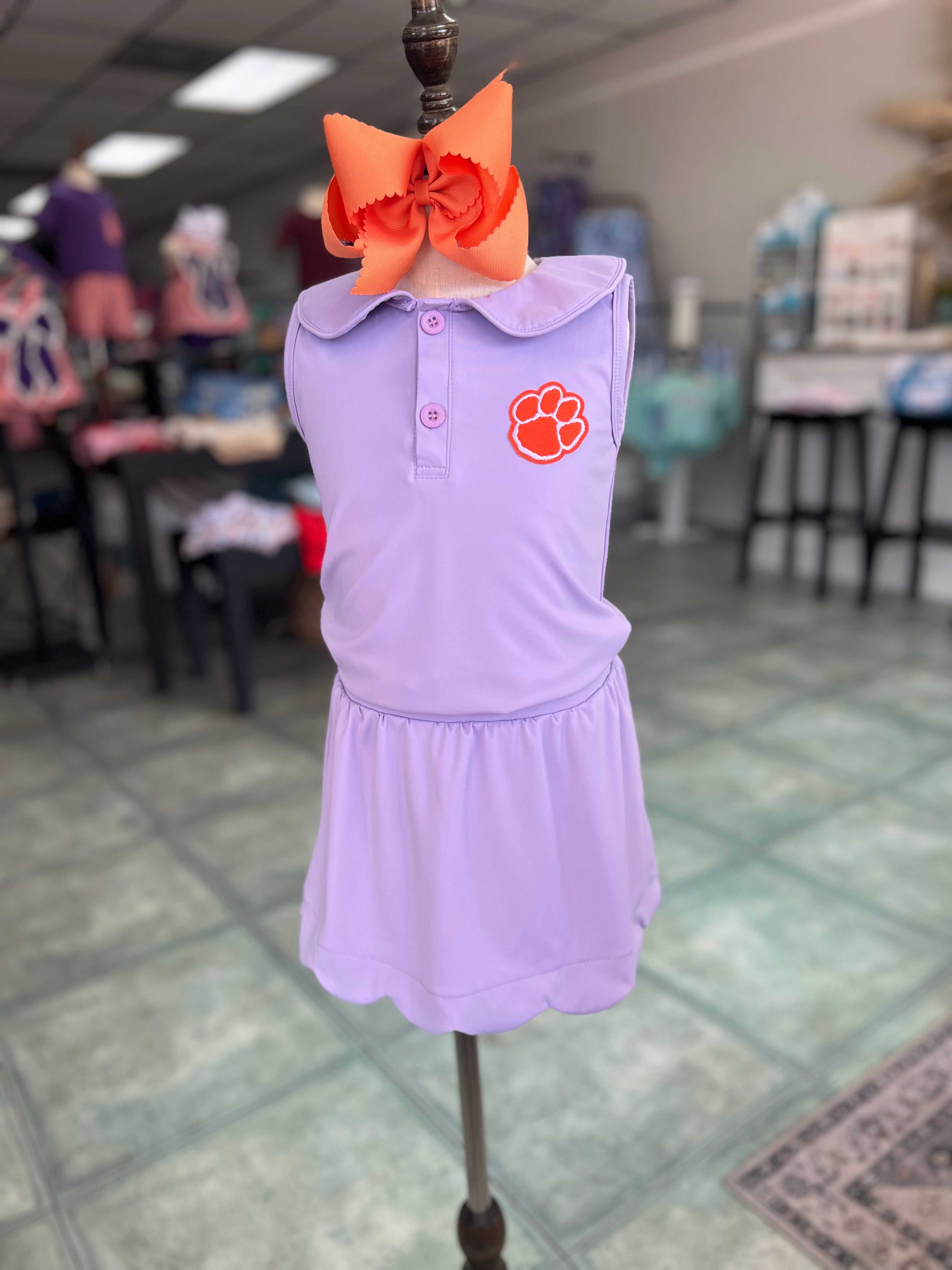 Lavender dress with orange accents on a mannequin in a store setting