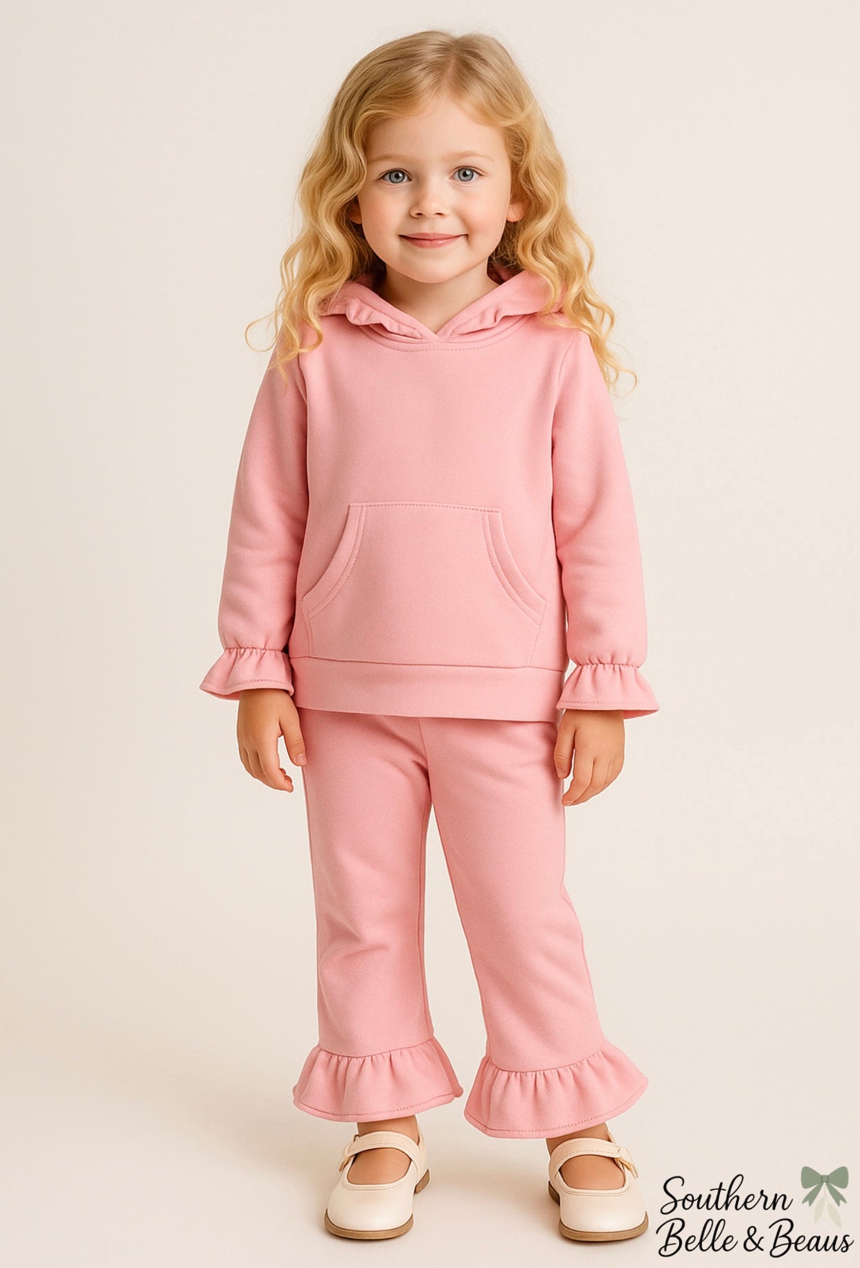 Young girl wearing a pink outfit with ruffled details.