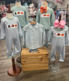 Children's clothing with festive designs on mannequins in a store setting.