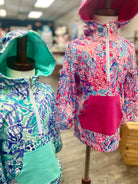 Two colorful hoodies on mannequins in a store setting