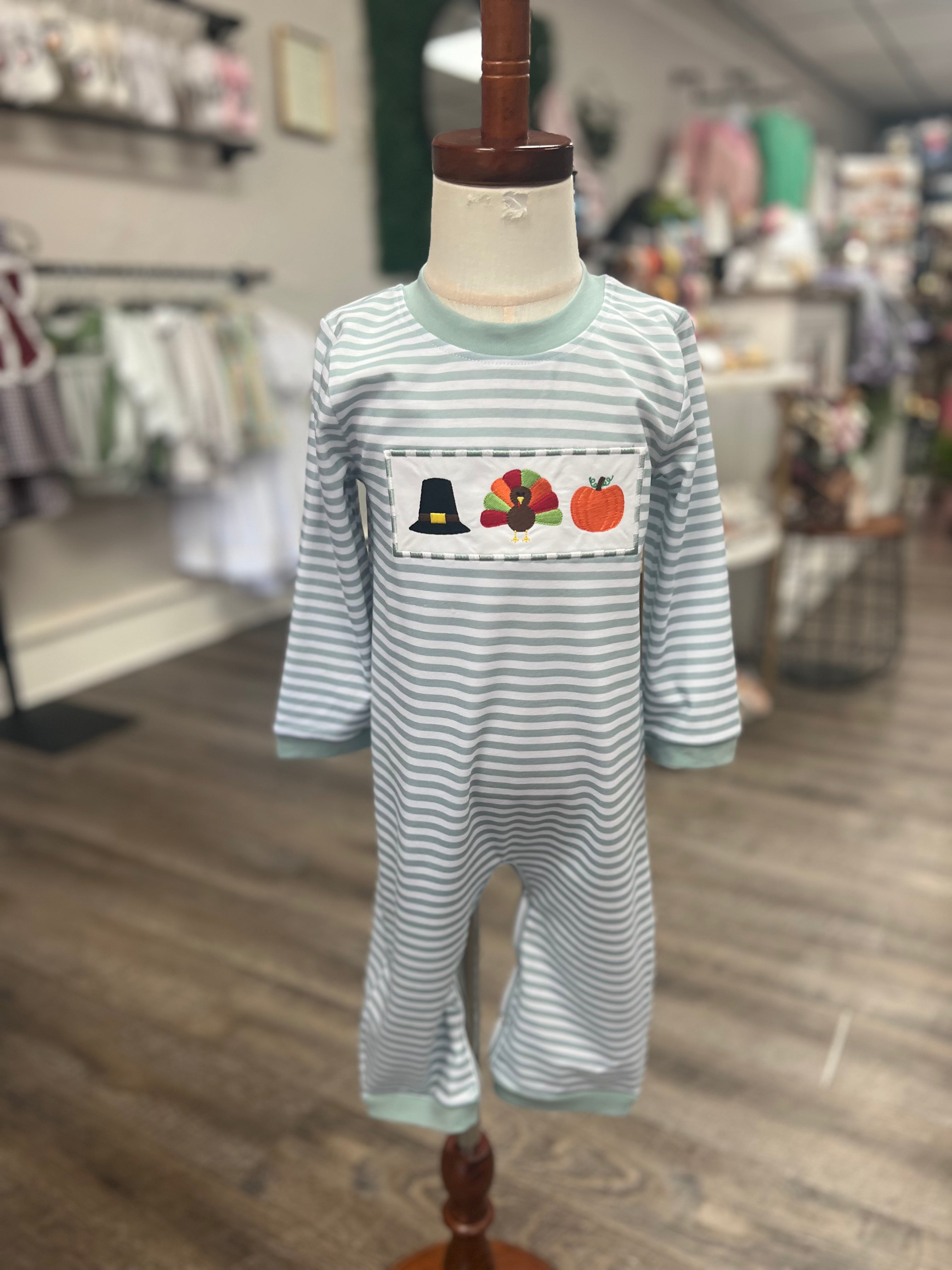 Striped onesie with embroidered design on a mannequin in a store setting