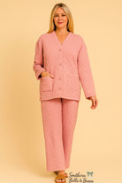Woman wearing a pink quilted pajama set against a beige background