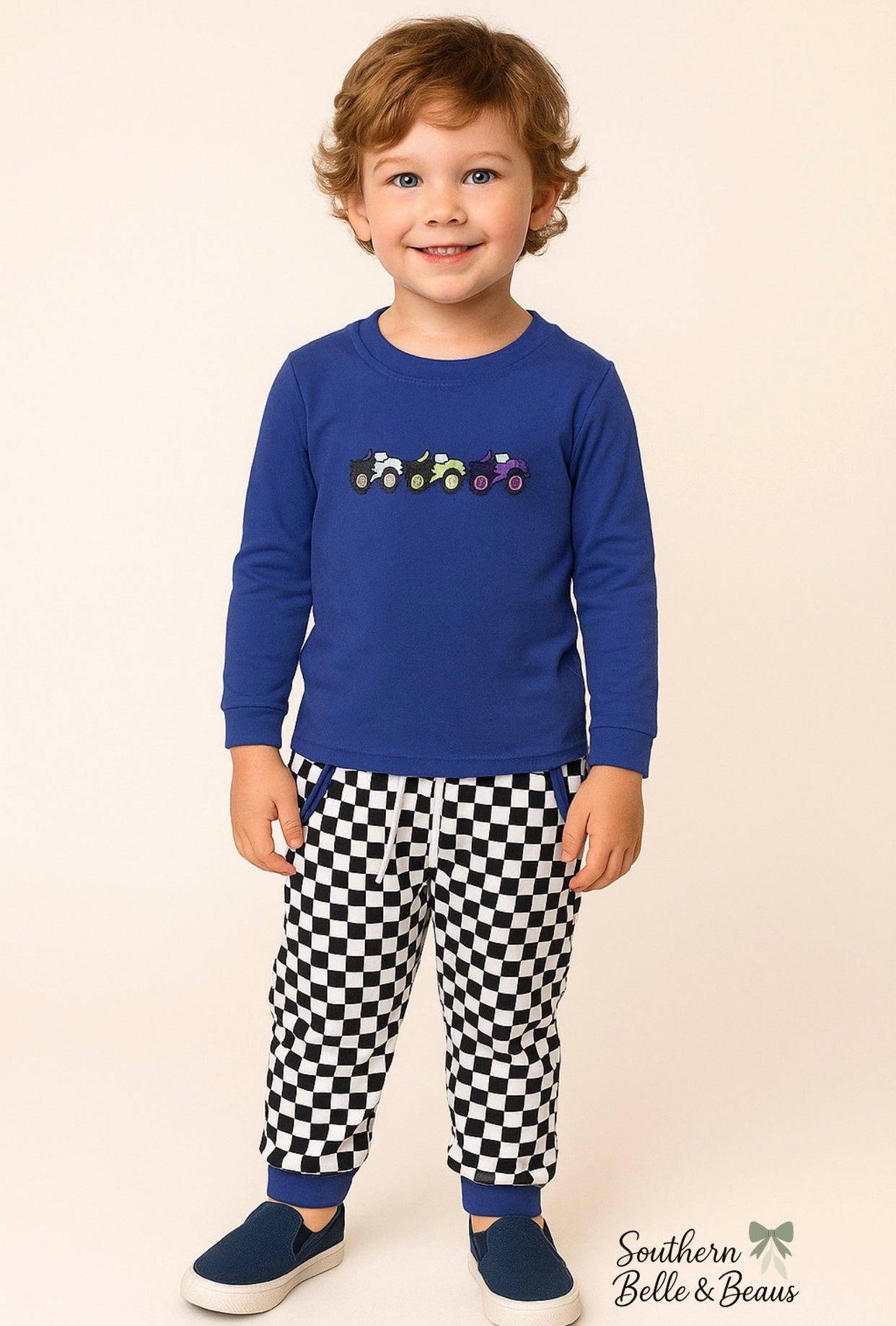 Ready to race! The Big Pit Stop Racer jogger set features a monster truck top and checkered joggers with pockets, elastic waistband, and drawstring.