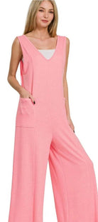 Woman wearing a pink jumpsuit on a plain background