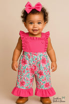 Child wearing a pink top and floral overalls with a bow on a beige background