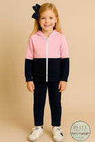 Pink and navy colorblock girls hoodie named “Zuri’s Zip-Up” displayed with matching navy bow and white sneakers from Southern Belle & Beaus.