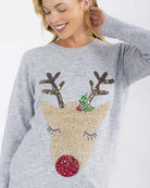 Woman wearing a gray sweater with a reindeer design on a white background