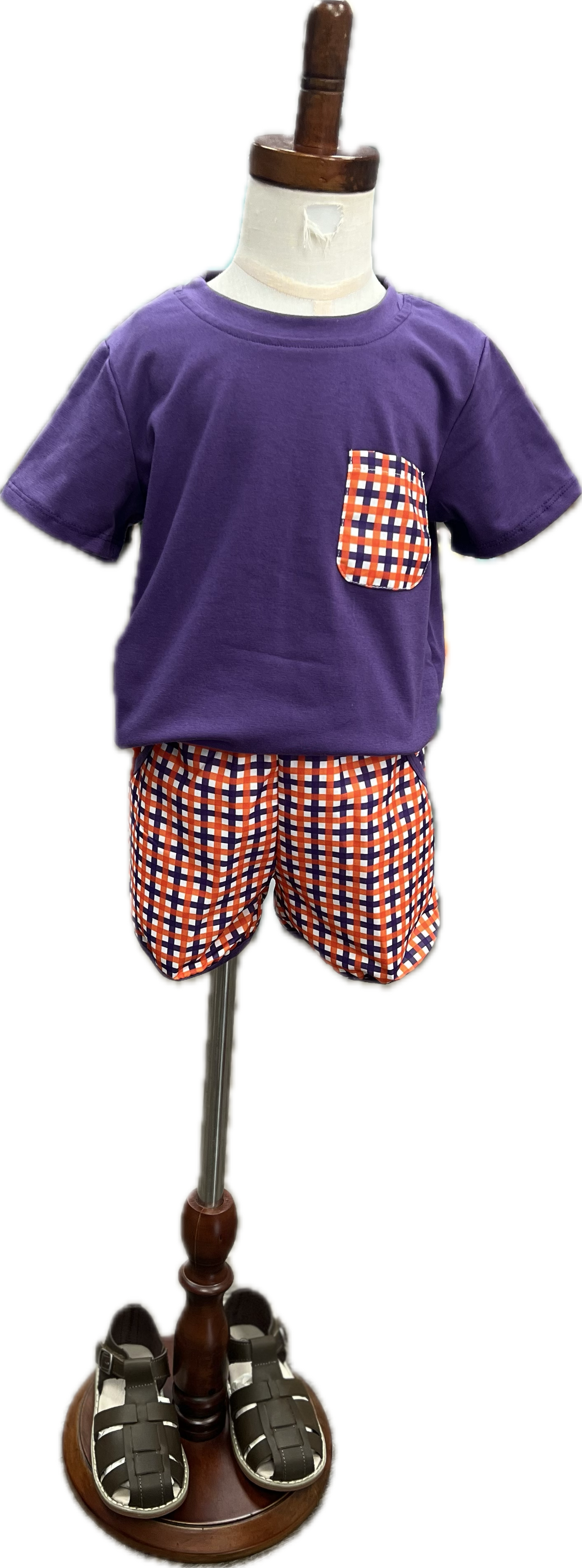 Children's outfit with purple shirt and checkered shorts on a mannequin with a white background