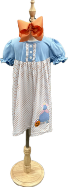 Children's dress with polka dot pattern and embroidered design on a mannequin.