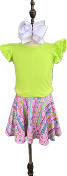 Green top and pink skirt with star pattern on a mannequin against a white background