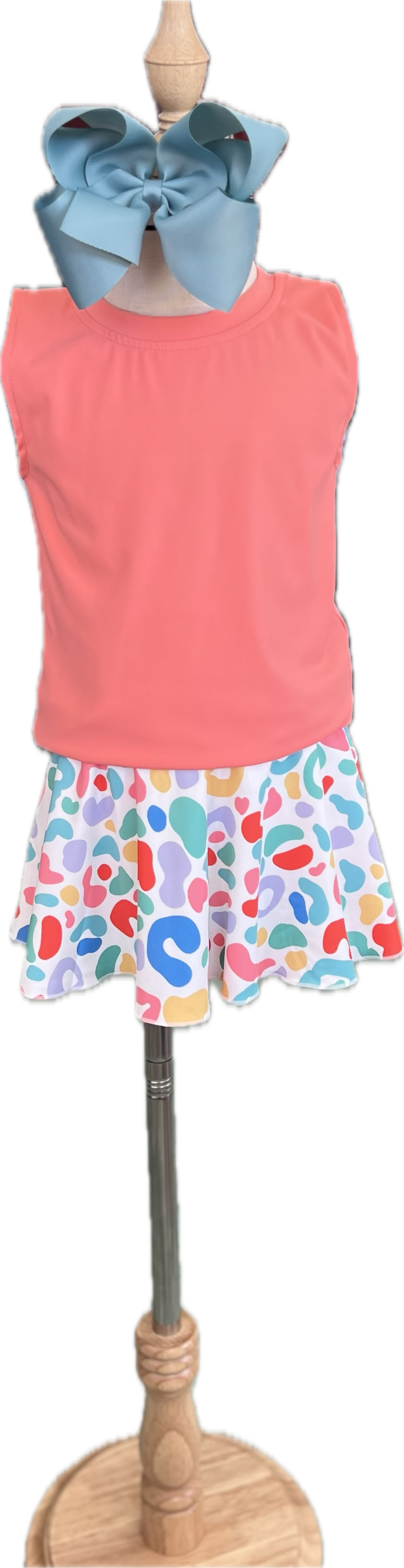 Mannequin wearing a coral sleeveless top and colorful patterned skirt with a blue headband.