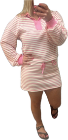 Pink and white striped dress with pink accents worn by a person on a white background