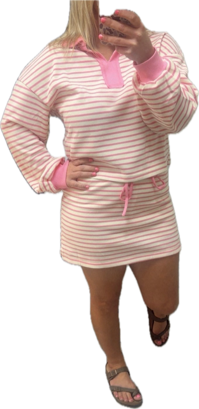 Pink and white striped dress with pink accents worn by a person on a white background