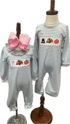 Two children's outfits on mannequins with striped pattern and embroidered designs.