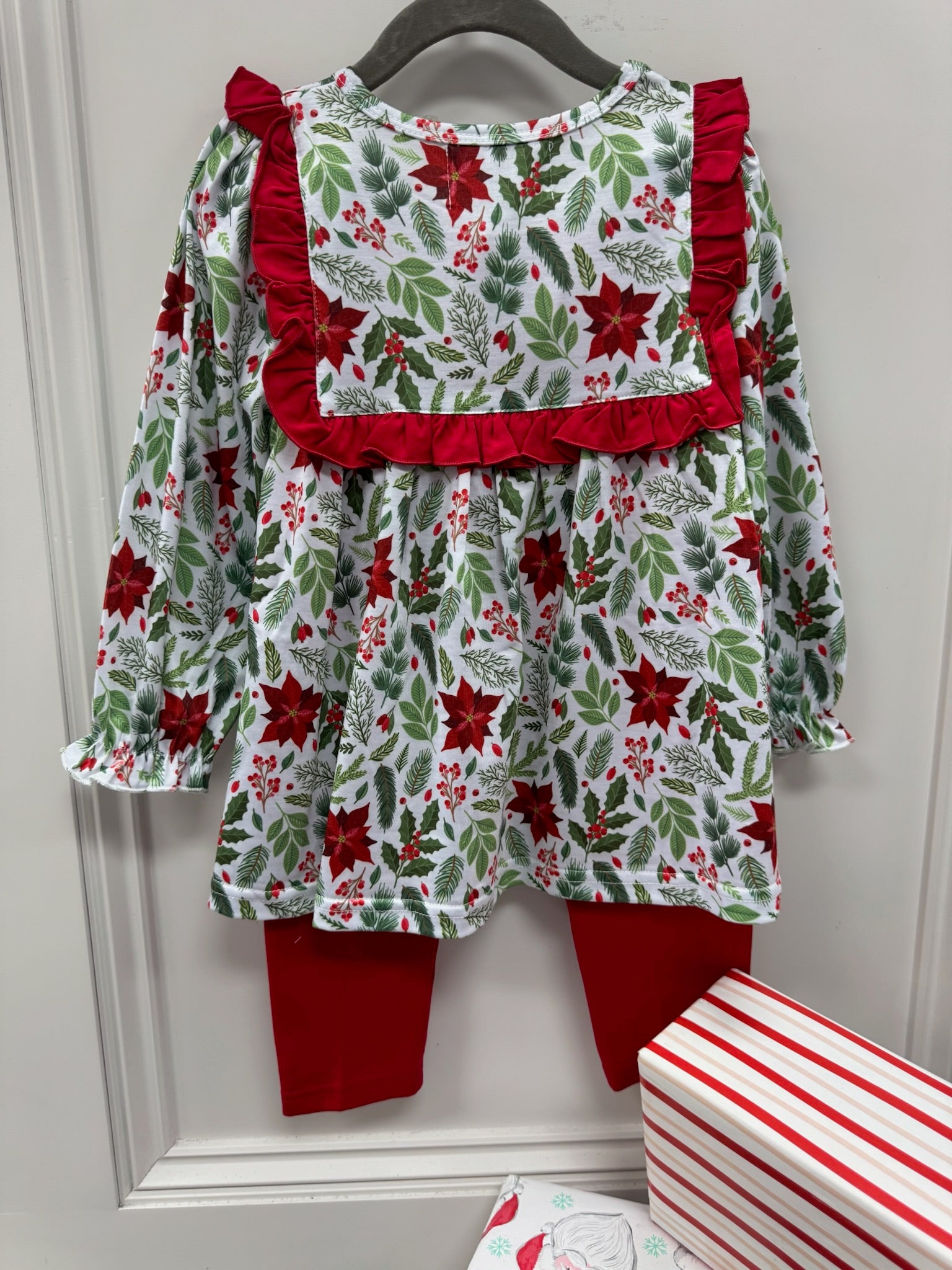 Girls long sleeve outfit with mistletoe floral print, collar trimmed in red ruffles with red pants.