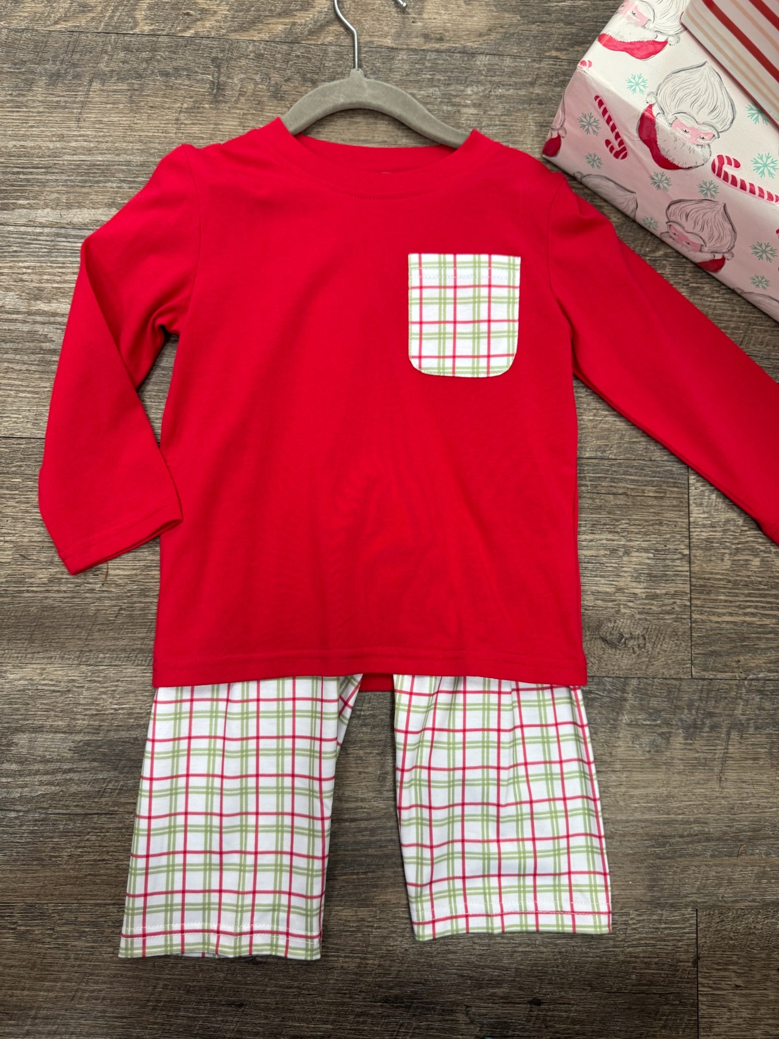 Red long sleeve shirt with a Christmas themed plaid print pocket with matching pants.