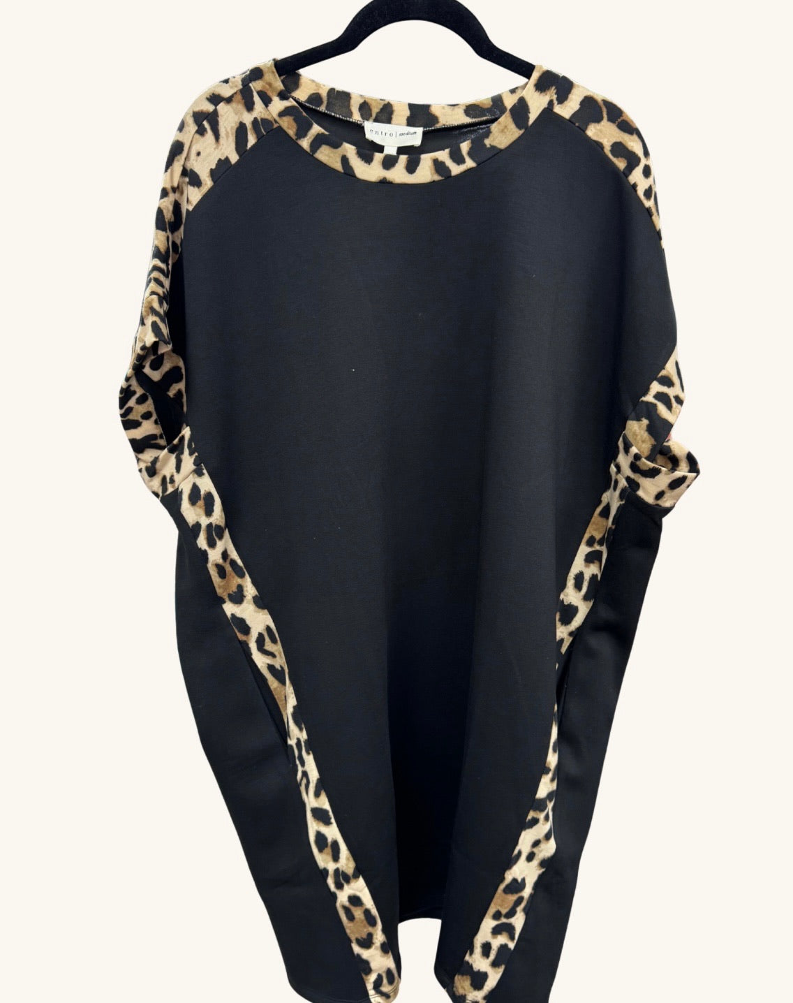 Black shift dress with leopard print trim along the neckline, sleeves, and side panels, featuring a relaxed batwing silhouette.