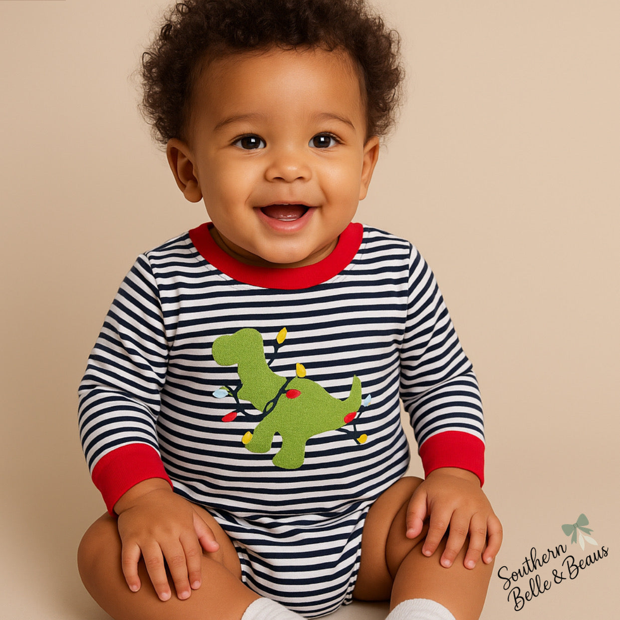 Baby striped romper with a dinosaur tangled in Christmas lights. 