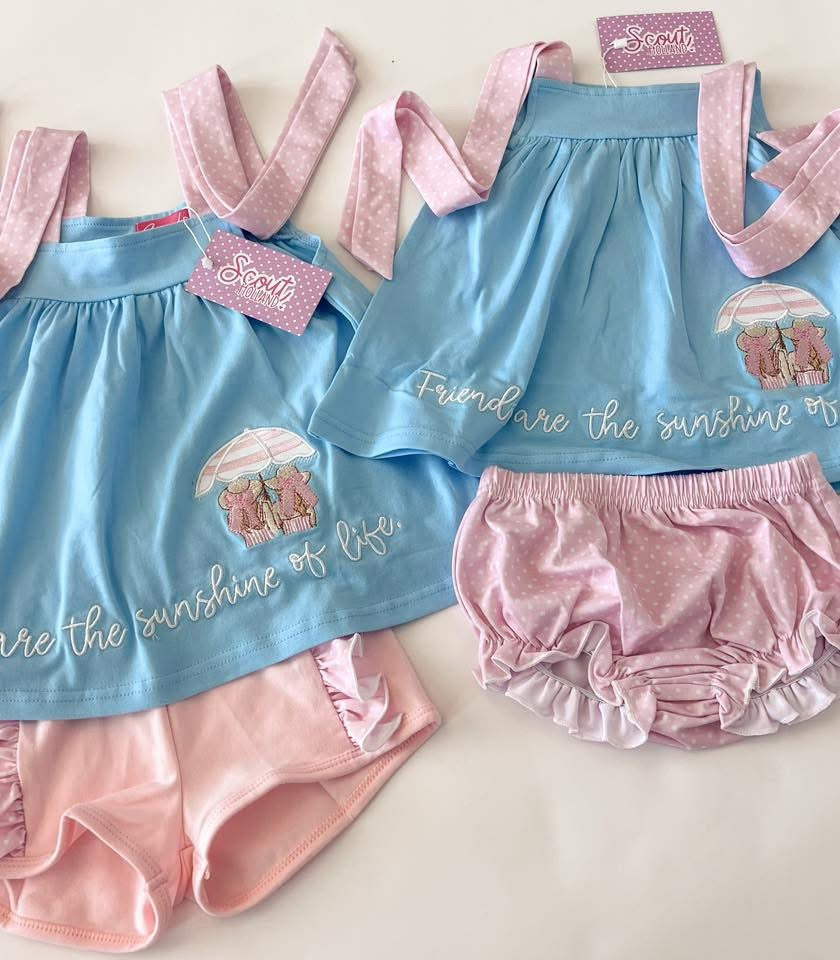 Children's blue dress with pink accents and text on a white background