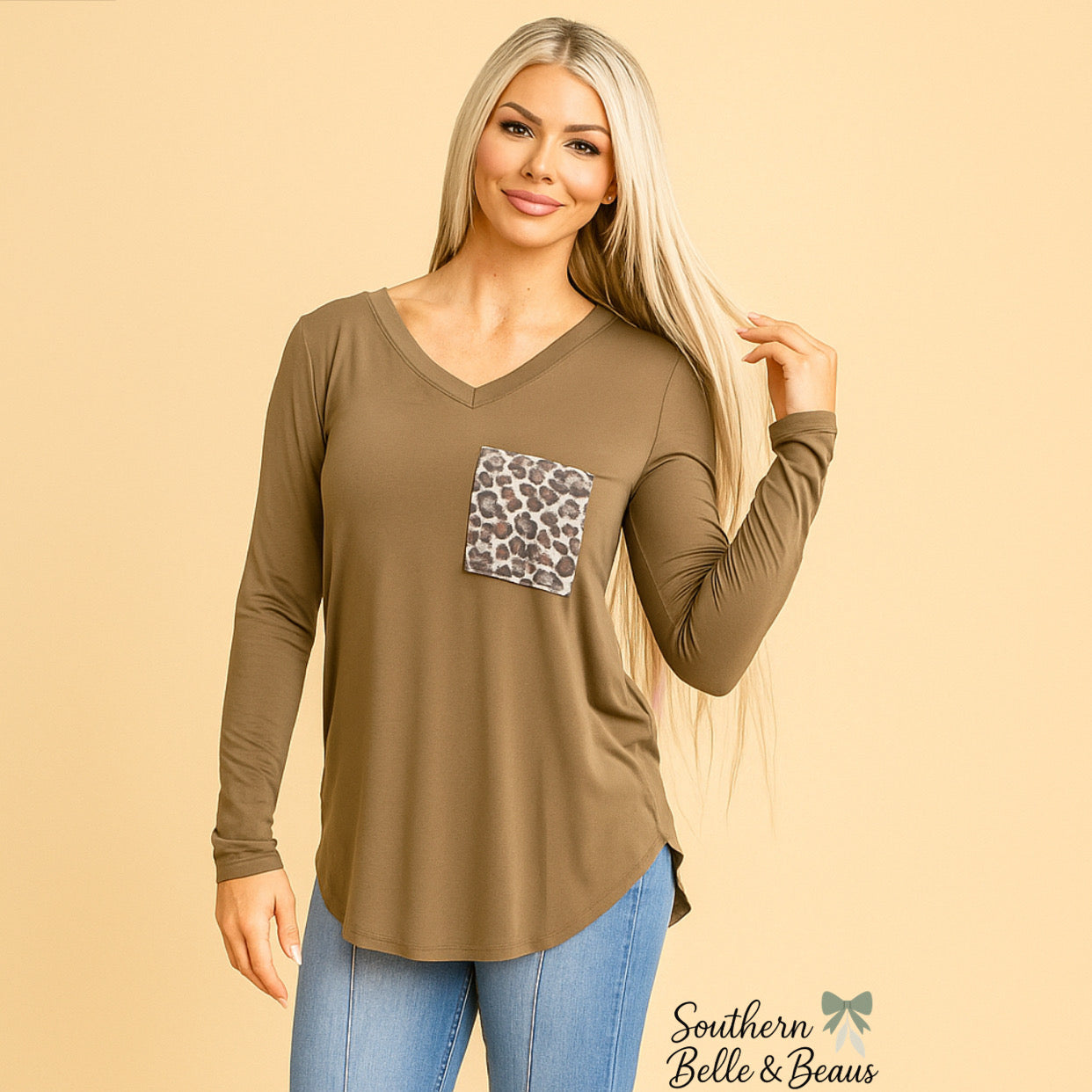 Woman wearing a brown long-sleeve top with a leopard print pocket on a beige background.