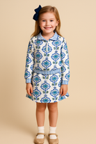 Girls blue floral two-piece set with striped trim — quarter-zip top and ruffle-waist skirt hanging on display.