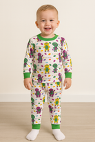 Child wearing a dinosaur-themed pajama set on a plain background
