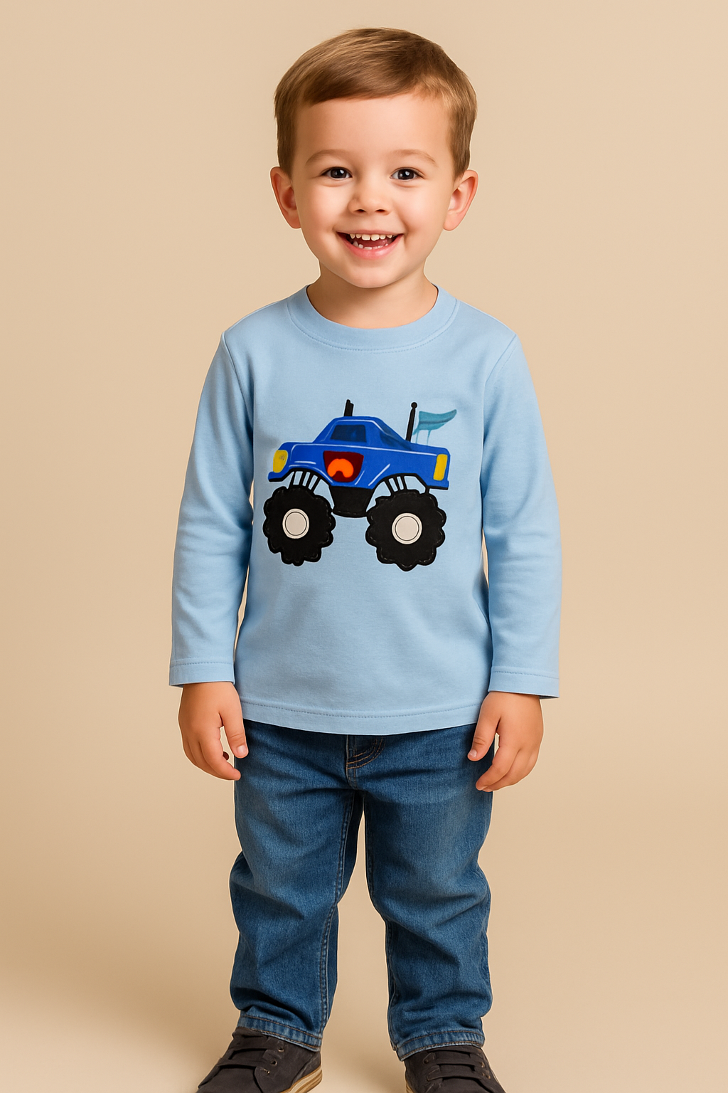Child wearing a blue shirt with a monster truck graphic on a beige background