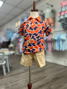 Colorful floral shirt and beige shorts on a mannequin in a store setting