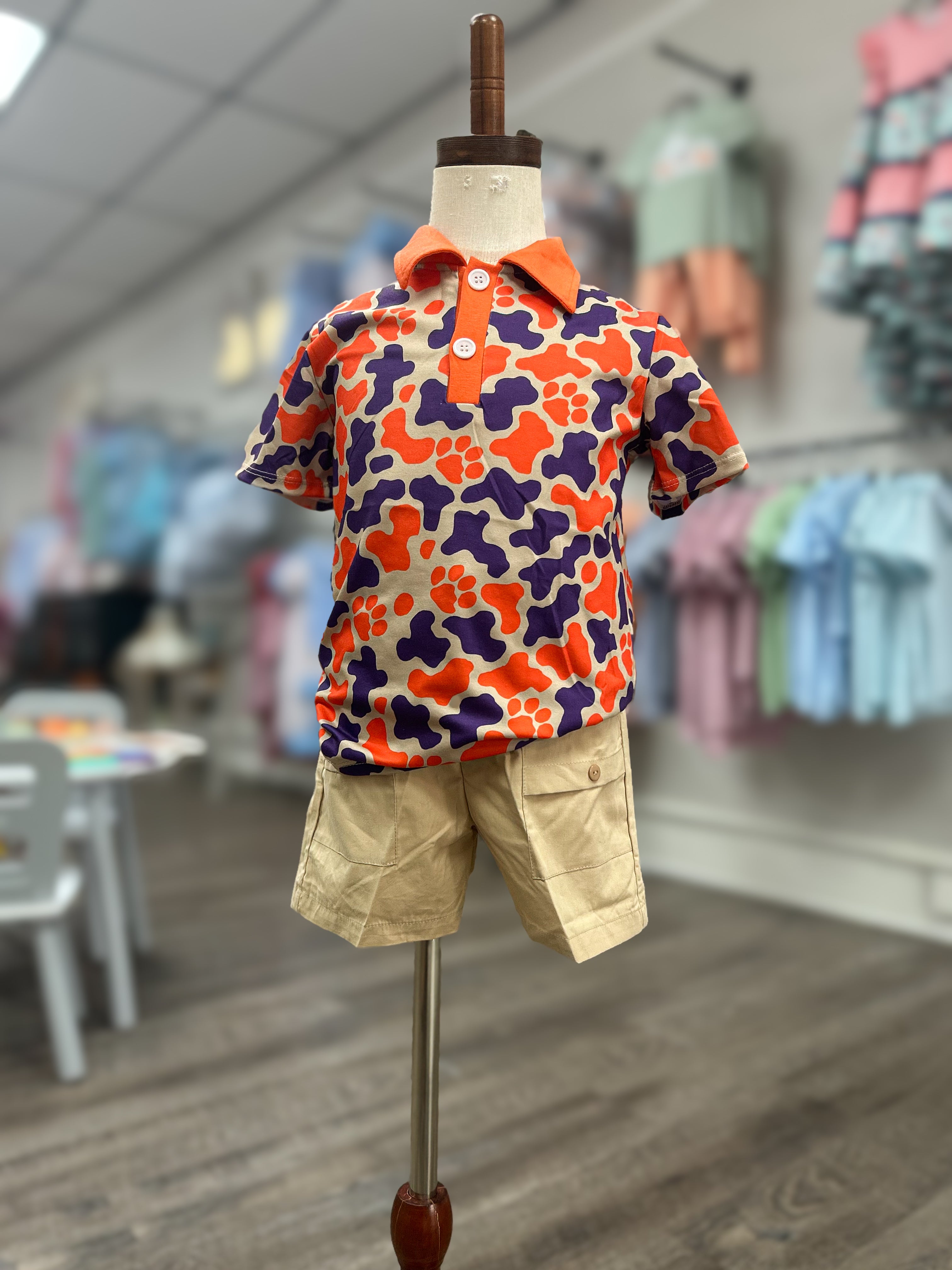 Colorful floral shirt and beige shorts on a mannequin in a store setting