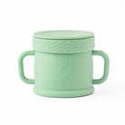 Mint green cup with handle and lid on a white background