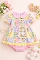 Colorful patchwork dress with floral and striped patterns on a light background with flowers and a teddy bear.