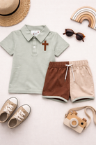 Sage green polo with an embroidered cross and drawstring brown & khaki shorts. 