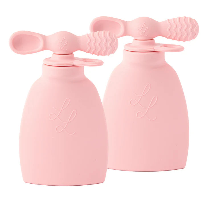 Two pink silicone baby soothers on a white background